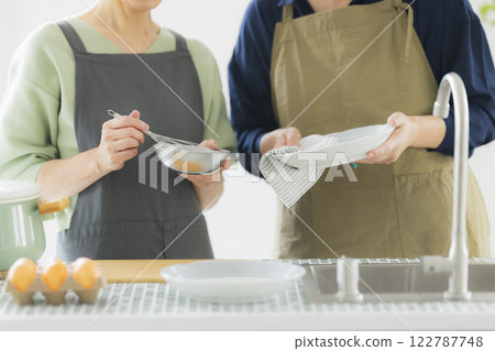 Two women standing in the kitchen 122787748