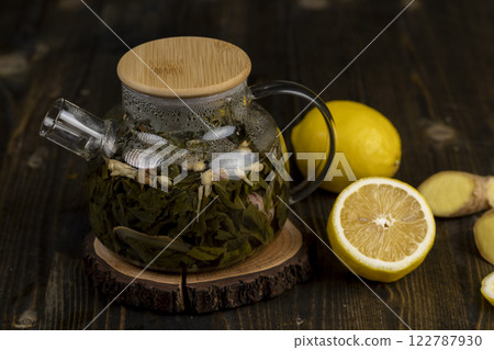 making green tea in a glass teapot with lemon and mint 122787930