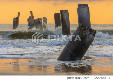A beautiful sunrise at Sao Eang Beach (Old leaning cement pillars) Cha-Am beach is a famous about a lot of old leaning cement pillars of the pier located in Cha-Am beach Phetchaburi Thailand A beautiful sunrise at Sao Eang Beach (Old leaning cement pillars) Cha-Am beach is a famous about a lot of old leaning cement pillars of the pier located in Cha-Am beach Phetchaburi Thailand 122788194