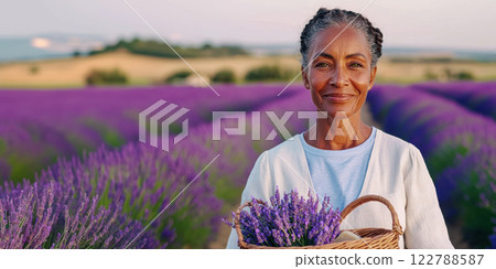 banner with an elderly lady with a basket of handmade soap against the background of a blooming lavender field, copy space about cosmetics from natural oils and herbs 122788587