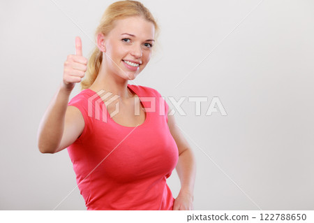 Happy woman showing thumbs up gesture Happy woman showing thumbs up gesture 122788650