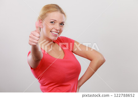 Happy woman showing thumbs up gesture Happy woman showing thumbs up gesture 122788652