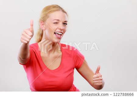 Happy woman showing thumbs up gesture Happy woman showing thumbs up gesture 122788666