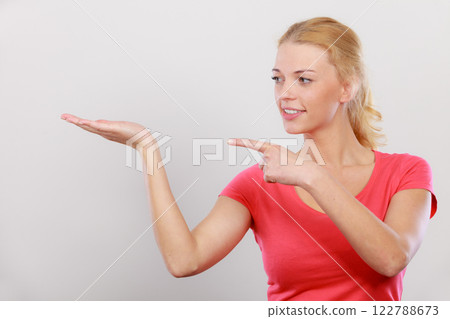 Happy woman pointing on left side 122788673