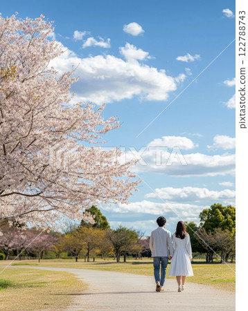 Vertical poster with couple in love walking in spring park under blooming sakura trees, Valentine's day 122788743