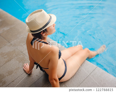Young woman relaxing by the pool at a Kuala Lumpur hotel Young woman relaxing by the pool at a Kuala Lumpur hotel 122788815