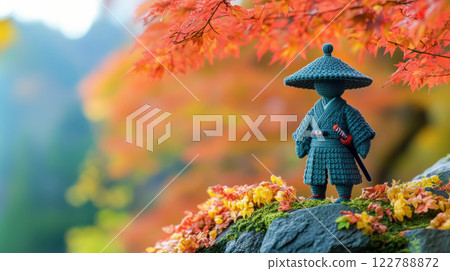 banner with a figurine of a samurai crocheted from wool against the background of an autumn forest, handmade toys banner with a figurine of a samurai crocheted from wool against the background of an autumn forest, handmade toys 122788872