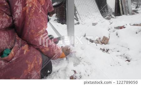 A person working on construction in a snowy environment, demonstrating resilience and determination. A person working on construction in a snowy environment, demonstrating resilience and determination. 122789050