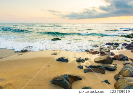 summer vacation landscape at the beach. dramatic seascape at sunrise. calm wave washing the coast with sand and rocks. beautiful view of sky with sun and cloud above horizon summer vacation landscape at the beach. dramatic seascape at sunrise. calm wave washing the coast with sand and rocks. beautiful view of sky with sun and cloud above horizon 122789919