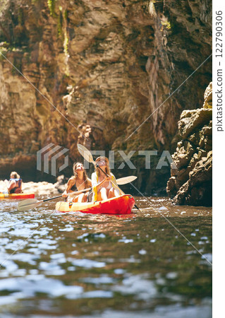 Travel, kayak and female friends on an adventure while on a lake or sea with a mountain view in nature. Women having fun while traveling and enjoying water activity while on a vacation holiday trip 122790306