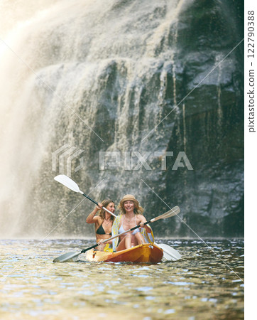 Kayak, summer and friends on river, nature and vacation adventure together in bikini swimsuit. Holiday, waterfall and freedom with young happy women rowing in a canoeing boat travel activity Kayak, summer and friends on river, nature and vacation adventure together in bikini swimsuit. Holiday, waterfall and freedom with young happy women rowing in a canoeing boat travel activity 122790388