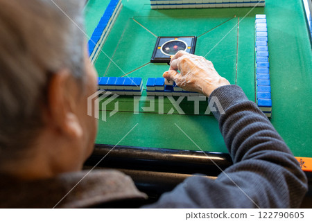 一位老人在電動麻將桌上打麻將的手 122790605