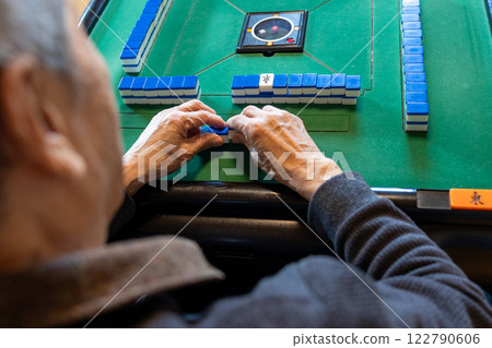 一位老人在電動麻將桌上打麻將的手 122790606