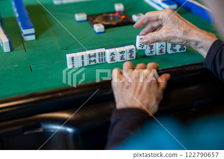 一位老年婦女在電動麻將桌上打麻將的手 122790657