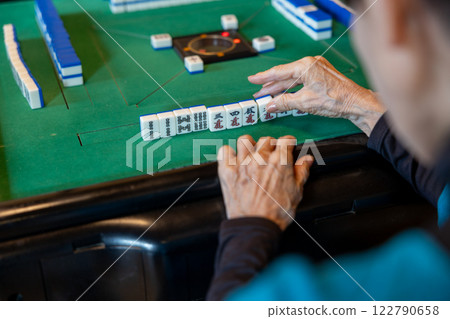 The hands of a senior woman playing mahjong on an electric mahjong table The hands of a senior woman playing mahjong on an electric mahjong table 122790658