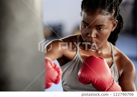 Woman, boxing and gym training workout for strong and motivated athlete fighter fitness. Hand coordination, focus and concentration for punching bag strike exercise in sports facility. 122790706