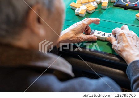 一位老人在電動麻將桌上打麻將的手 122790709