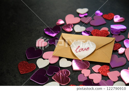 multicolored hearts on dark background and envelope 122790910
