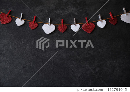 On a dark background on a string of hearts 122791045
