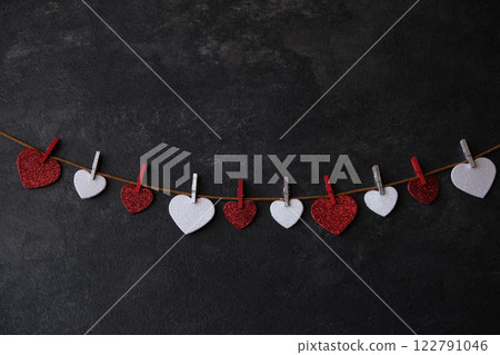 On a dark background on a string of hearts 122791046
