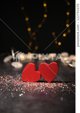 Two hearts side by side on a dark background and garlands 122791070