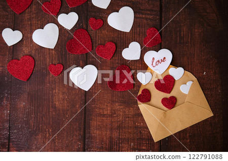 An envelope with an envelope and hearts on a wooden background 122791088