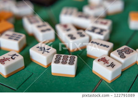 Mahjong tiles scattered on an electric mahjong table, with the wind tile in focus to the east Mahjong tiles scattered on an electric mahjong table, with the wind tile in focus to the east 122791089