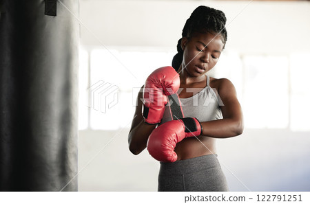 Healthy, fitness and cardio woman boxer thinking about a fight, competition or match in the gym or health club. Young athlete training, exercise and workout in a fitness studio and sport motivation Healthy, fitness and cardio woman boxer thinking about a fight, competition or match in the gym or health club. Young athlete training, exercise and workout in a fitness studio and sport motivation 122791251