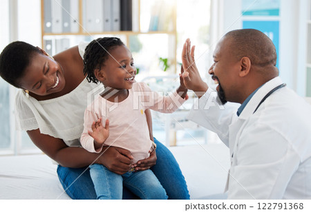 Healthcare, mother and girl gives doctor high five in a doctors office. Medical insurance, healthy child development and consulting in a doctors office. Black woman, daughter and pediatrician smiling 122791368