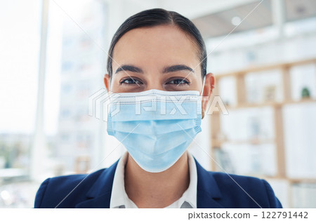 Safety, compliance and face mask covid regulations at work with a young employee in an office. Corporate professional smiling and looking positive, enjoying her career and hygiene at the workplace 122791442