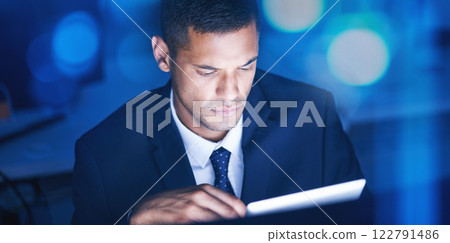 Businessman with digital tablet overtime for data research in a corporate office at night. Male entrepreneur and executive worker using technology to communicate and network with online app or email Businessman with digital tablet overtime for data research in a corporate office at night. Male entrepreneur and executive worker using technology to communicate and network with online app or email 122791486