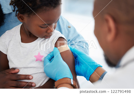 Child, healthcare vaccine and doctor with plaster for skin protection after injection appointment. Black kid and medical worker with bandage for healing of wound from needle medicine immunity. Child, healthcare vaccine and doctor with plaster for skin protection after injection appointment. Black kid and medical worker with bandage for healing of wound from needle medicine immunity. 122791498