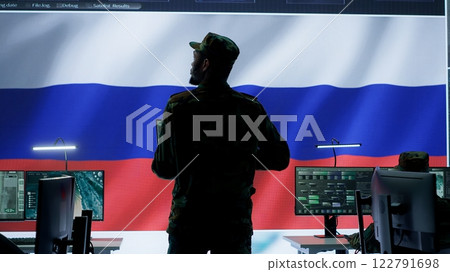 Military expert from Russian army working in governmental base of operations, breaking into rival states servers to spread fake news and hybrid war propaganda. Brainwashing population. Camera A. Military expert from Russian army working in governmental base of operations, breaking into rival states servers to spread fake news and hybrid war propaganda. Brainwashing population. Camera A. 122791698