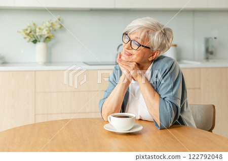 Good morning. Comfort relaxed senior old elderly woman grandmother drinking hot beverage tea coffee in kitchen at home. Mature woman resting enjoy calm morning at modern home alone. Pension concept 122792048