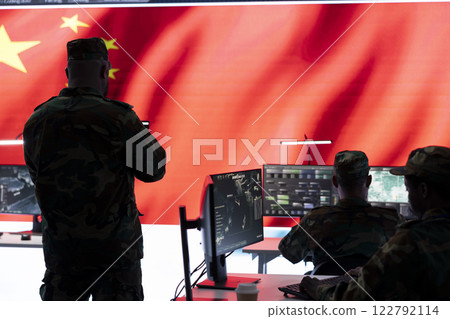 Chinese military command officer analyzing data on computers in an army base of operations. Spreading state secrets of rival countries and promoting propaganda for communism. Chinese military command officer analyzing data on computers in an army base of operations. Spreading state secrets of rival countries and promoting propaganda for communism. 122792114