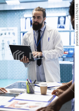 Healthcare professionals attending a strategy meeting in a medical center, focusing on treatment plans for disease prevention. General practitioner exploring healthcare improvement initiatives. Healthcare professionals attending a strategy meeting in a medical center, focusing on treatment plans for disease prevention. General practitioner exploring healthcare improvement initiatives. 122792146