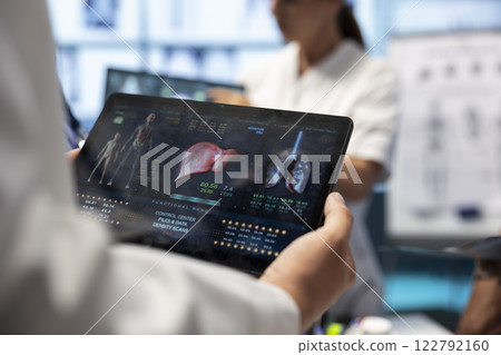 Professional doctor analyzing lungs and liver radiography test result for diagnostic, working on disease prevention in cabinet. Specialist at private clinic examine ct scan and x ray. Close up. Professional doctor analyzing lungs and liver radiography test result for diagnostic, working on disease prevention in cabinet. Specialist at private clinic examine ct scan and x ray. Close up. 122792160