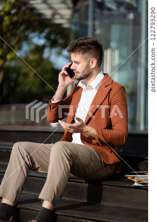 Businessman Talking on Mobile Phone in City. 122793290