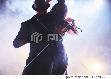 Skillful dancers performing in the dark room under the concert light and smoke. Sensual couple performing an artistic and emotional contemporary dance 122793695