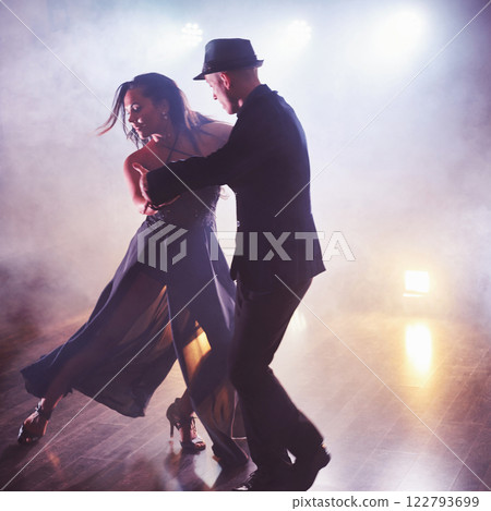 Skillful dancers performing in the dark room under the concert light and smoke. Sensual couple performing an artistic and emotional contemporary dance 122793699