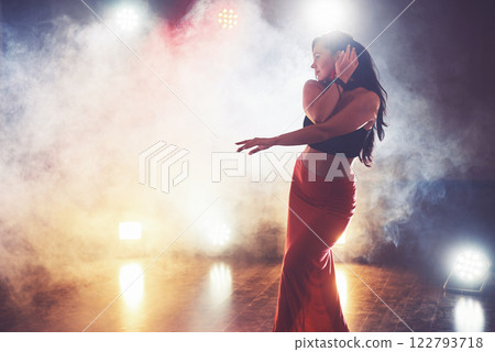 Skillful and beautiful dancer girl performing in the dark room under the concert light and smoke, performing an artistic and emotional contemporary dance Skillful and beautiful dancer girl performing in the dark room under the concert light and smoke, performing an artistic and emotional contemporary dance 122793718