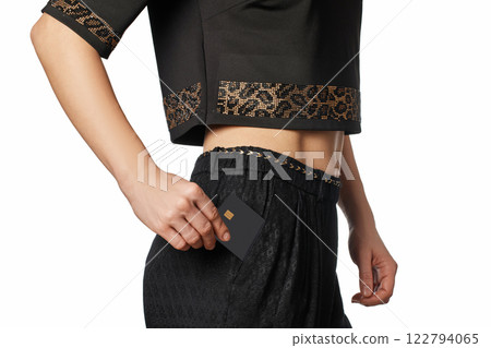 female hand putting black premium credit bank card in pants pocket. cashless transactions. Payment for purchases 122794065