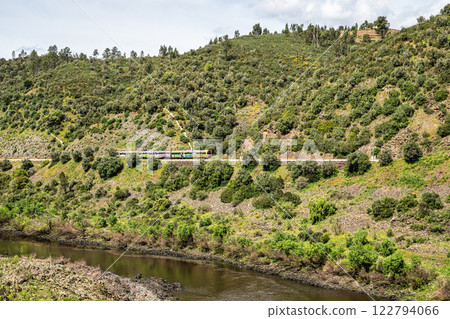 A train going alongside the Barca da Amieira walkways in Amieira do Tejo, Portugal. 122794066