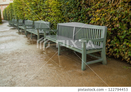 Green wet benches on field of grass with leaves in the background Green wet benches on field of grass with leaves in the background 122794453