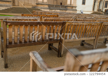 A modern wooden benches standing in the park. Comfortable bench in recreation area. City improvement, urban planning, public spaces. A modern wooden benches standing in the park. Comfortable bench in recreation area. City improvement, urban planning, public spaces. 122794454