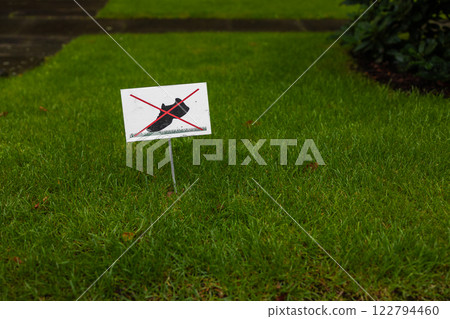 No walking on grass sign. Do not step on lawn warning symbol. Prohibition signpost on lawn. Forbidding harm to nature. Red and white road sign for environmental protection. Crossed out icon. 122794460