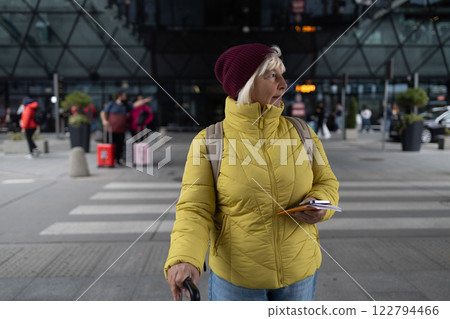 Traveler tourist mature elderly senior lady woman 55 years old wears style clothes hold suitcase bag outdoors near at airport Traveler tourist mature elderly senior lady woman 55 years old wears style clothes hold suitcase bag outdoors near at airport 122794466