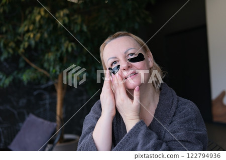 black patches under the eyes Girl in white towel opened her mouth in surprise. Woman with red lipstick posing with black patches under eyes 122794936