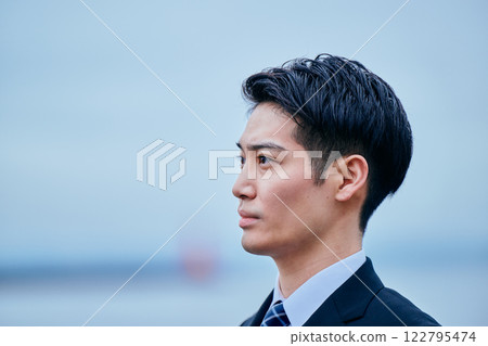 一位穿著西裝的年輕人望著遠方 122795474
