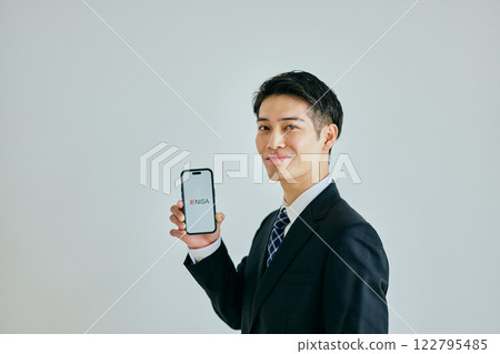 A young man in his twenties holding a smartphone A young man in his twenties holding a smartphone 122795485